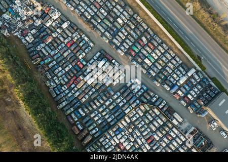 Luftaufnahme des großen Parkplatzes von Schrottplatz mit Reihen von weggeworfenen gebrochenen Autos. Recycling von Altfahrzeugen Stockfoto