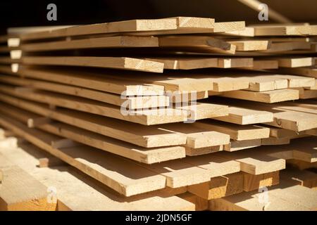 Platten auf Lager. Weiße Bretter liegen im Stapel. Baumaterial in der Schreinerei. Stockfoto