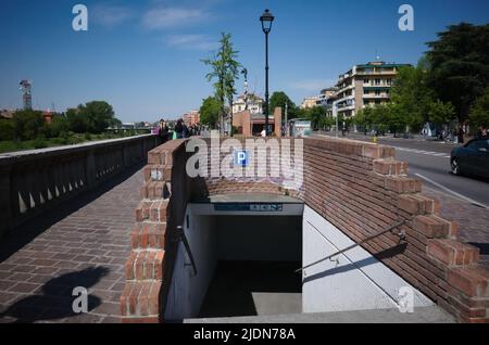 Parma, Italien - Mai 2022: Eingang zu Tiefgarage und unterirdischer Fußgängerüberweg aus Ziegelsteinen am Ufer der Viale Toschi Straße Stockfoto