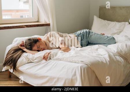 Deprimiert frustrierte junge Frau ist traurig, tagsüber auf dem Bett zu liegen. Stockfoto