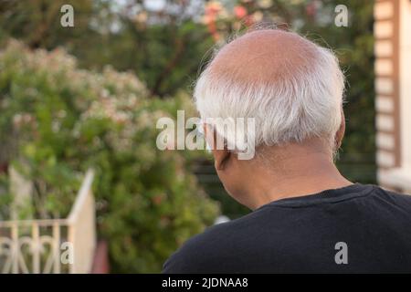 Weißhaariger, nicht identifizierter älterer Mann, der von oben nach unten blickt, mit Rückenhaltung Stockfoto