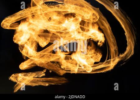 Flammen auf langem Beil. Spuren von Feuer im Dunkeln. Flammen breiten sich chaotisch im Weltraum aus. Stockfoto