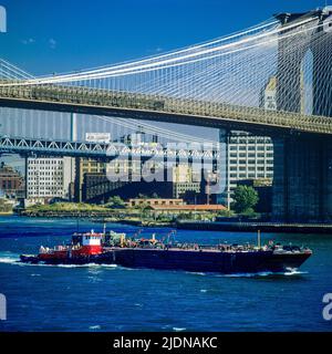 New York 1980s, Brooklyn Bridge, East River, Schlepper mit einem Lastkahn, New York City, NYC, NY, USA, Stockfoto