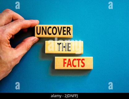 Entdecken Sie das Facts-Symbol. Concept Words enthüllen die Fakten auf Holzblöcken auf einem wunderschönen blauen Hintergrund. Geschäftsmann Hand. Business und U Stockfoto