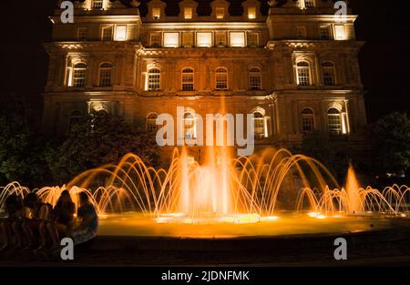 Wasserbrunnen, beleuchtet in der Dämmerung, Place Vauquelin, Old Montreal, Quebec, Kanada. Stockfoto