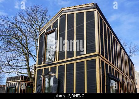 Ein einfaches, modernes, zweistöckiges privates Holzhaus im Bau, blauer Himmel im Hintergrund Stockfoto
