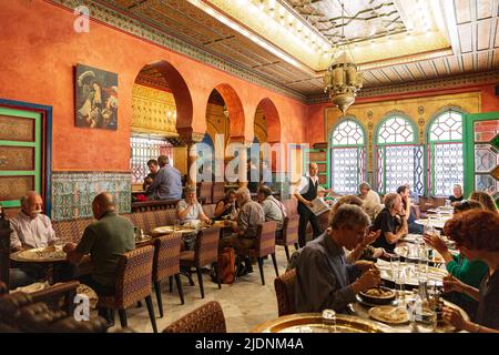 Die Gäste der großen Moschee von Paris sitzen an kleinen Tischen im Schatten der Feigenbäume Stockfoto