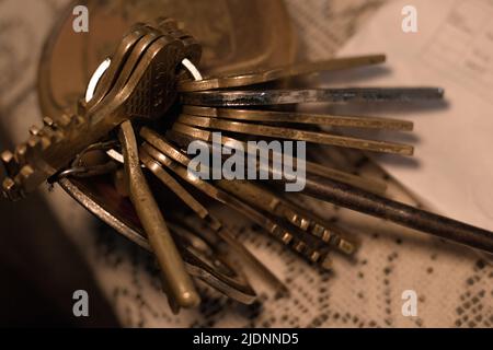 Schlüsselbund mit Schloss auf weißer Oberfläche. Stockfoto