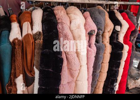 Pelzmäntel mit Kunstpelz auf einem Kleiderbügel auf dem Markt Stockfoto