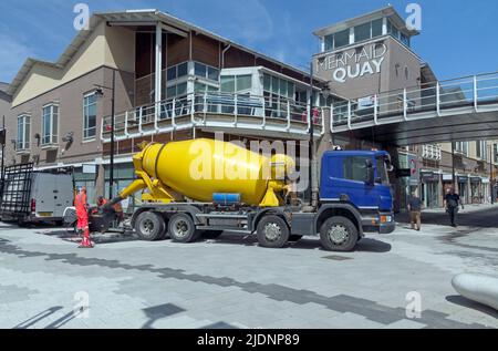 Gelber Transportbetonwagen, der am Mermaid Quay in Cardiff Bay arbeitet, Sommer 2022 Stockfoto