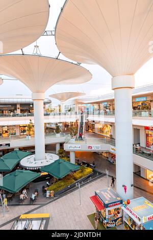 26. Mai 2022, Antalya, Türkei: Ungewöhnliches Interieur einer modernen Erasta Mall ohne Dach und futuristische Säulenbäume und Handelsgeschäfte Stockfoto