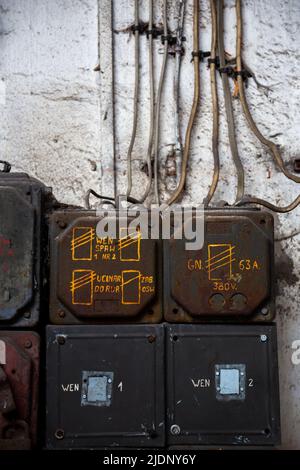 Alte Elektrotafel in einem verlassenen Gebäude. Aufnahme bei natürlichem, schwachem Licht Stockfoto