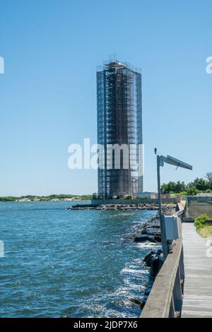 19. Juni 2022, Barnegat Light, NJ USA der ikonische Barnegat Lighthouse auf Long Beach Island, New Jersey, ist mit Gerüsten für Restaurierung und Malerei umhüllt und versteckt das unverwechselbare Wahrzeichen vor der Sicht. Stockfoto