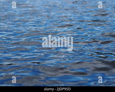 Blau, Grau und Schwarz des Himmels spiegeln sich in einer gewellten Seeoberfläche in Ottawa, Ontario, Kanada. Stockfoto