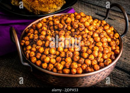 Sumac und Gewürz geröstete Kichererbsen: Geröstete Garbanzo-Bohnen, serviert in einer gehämmerten balti-Kupferschale Stockfoto