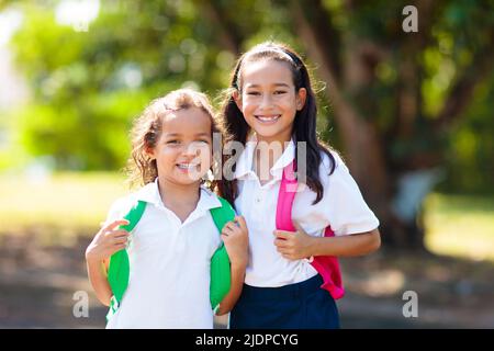 Die Kinder gehen zurück zur Schule. Interrassische Gruppe von Kindern unterschiedlichen Alters laufen und jubeln am ersten Tag des neuen akademischen Jahres. Beginn der Schulferien. Stockfoto