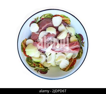 Rotes rohes Schweinefleisch in Stücke geschnitten, Zwiebel in Stücke geschnitten und Knoblauchzehen werden für Hackfleisch in einem Fleischwolf zubereitet. Stockfoto