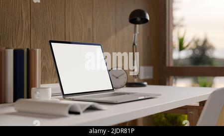 Komfortabler Heimarbeitsplatz mit tragbarem Laptop-Computer mit leerem Bildschirm, Tischlampe und Zubehör auf dem Tisch über der Holzwand. 3D Rendering, 3D i Stockfoto