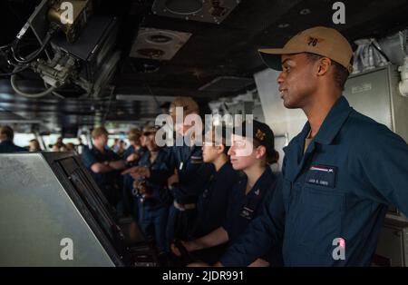 Santa Rita, Guam. 22.. Juni 2022. Matrosen stehen im Pilothouse zu beobachten, wie der einzige vorwärts eingesetzte Flugzeugträger der US-Navys, USS Ronald Reagan (CVN 76), zu einem planmäßigen Hafenbesuch zum Marinestützpunkt Guam einzieht. Ronald Reagan, das Flaggschiff der Carrier Strike Group 5, stellt eine kampfbereite Kraft zur Verfügung, die die Vereinigten Staaten schützt und verteidigt und Allianzen, Partnerschaften und kollektive maritime Interessen in der Indo-Pazifik-Region unterstützt. Quelle: U.S. Navy/ZUMA Press Wire Service/ZUMAPRESS.com/Alamy Live News Stockfoto