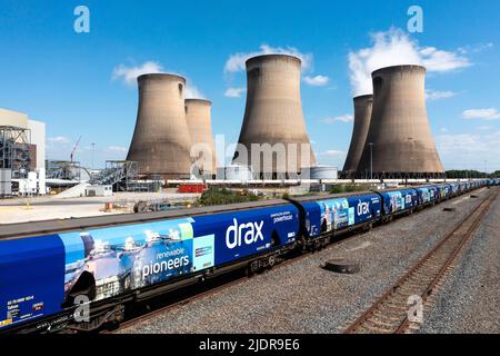 Luftaufnahme eines Güterzuges und von Waggons, die anstelle von Kohle erneuerbare Biomasse zum Kraftwerk Drax liefern, um den CO2-Fußabdruck zu reduzieren Stockfoto