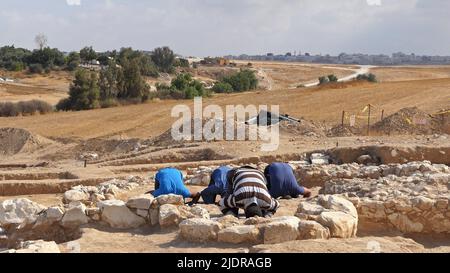 RAHAT, ISRAEL - 22. JUNI: Palästinensische Arbeiter der israelischen Antikenbehörde beten am 22. Juni 2022 in Rahat, Israel, inmitten der Überreste einer kürzlich entdeckten Moschee, die zu den ältesten weltweit bekannten (über 1200 Jahre alt) gehört. Große archäologische Ausgrabungen, die von Israel im Rahmen eines Plans zur Erweiterung der Beduinenstadt Rahat durchgeführt wurden, liefern grafische Details des religiösen Übergangs vom Christentum zum Islam im siebten bis neunten Jahrhundert. Kredit: Eddie Gerald/Alamy Live Nachrichten Stockfoto