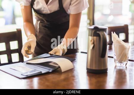 Der Kellner gibt dem Gast im Restaurant eine Rechnung. Stockfoto