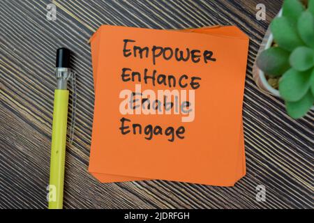Konzept von Empower, Enhance, Enable, Engage Personal Development Schreiben Sie auf Haftnotizen isoliert auf Holztisch. Stockfoto