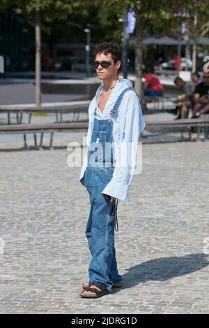 MAILAND, ITALIEN - 18. JUNI 2022: Mann mit Denim-Overalls und blauem Hemd vor der MSGM-Modenschau im Street-Style der Milan Fashion Week Stockfoto