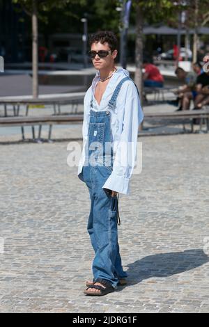 MAILAND, ITALIEN - 18. JUNI 2022: Mann mit Denim-Overalls und blauem Hemd vor der MSGM-Modenschau im Street-Style der Milan Fashion Week Stockfoto