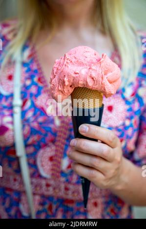 Frau hält Obst veganes Eis in Waffelkegel auf der Straße, Nahaufnahme Stockfoto
