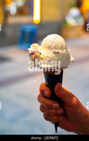 Frau hält Obst veganes Eis in Waffelkegel auf der Straße, Nahaufnahme Stockfoto