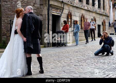 Hochzeitskuss - ein frisch verheiratetes Paar, das Hochzeitsfotos auf der Royal Mile in Edinburgh in der Nähe des Edinburgh Castle gemacht hat Stockfoto