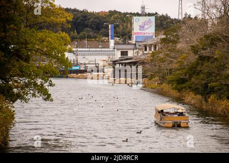 Matsue, Shimane, JAPAN - Dez 1 2021 : Ein Sightseeing-Boot, das am Abend den Horikawa Fluss in der Nähe von Matsue Castle entlang fährt. Raue und nostalgische Stimmung. Stockfoto