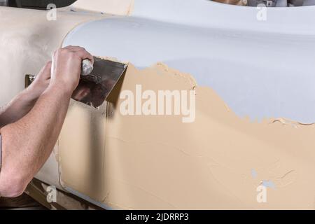 Nahaufnahme der Verwendung von zwei-Komponenten-Klebstoff an einem Auto Stockfoto