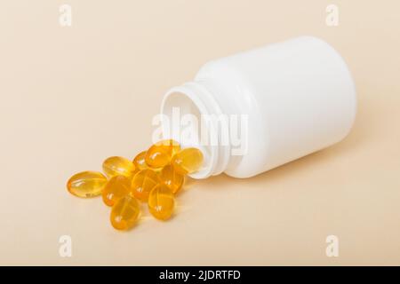 Omega-3 Kapseln liegen in einer weißen Flasche auf einem Tischhintergrund. Fischöl Tabletten Draufsicht. Biologisch aktive Zusatzstoffe. omega 6, Omega 9, Vitamin A, E, Stockfoto