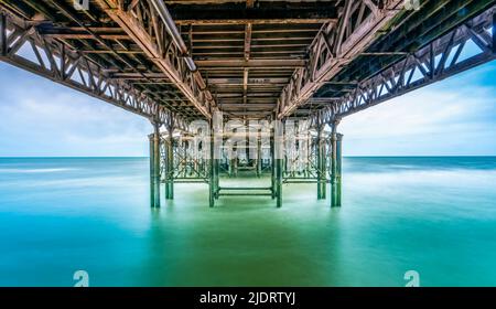 Langzeitbelichtung Fotografie fängt die Unterseite des Central Pier in Blackpool, Lancashire, Großbritannien bei Flut mit dem Meer sieht glatt und verschwommen Stockfoto