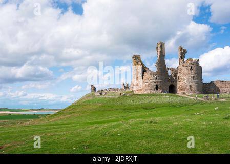 Dunstanburgh Castle, Blick im späten Frühjahr auf das zerstörte 14.. Jahrhundert Dunstanburgh Castle an der Northumberland Küste in der Nähe von Embleton Bay, England Stockfoto