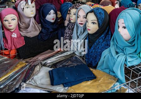 Eine Serie von Schaufensterpuppen, die bunte Kopftücher oder Hijabs tragen, in einem Marktstand in Turin, Italien Stockfoto