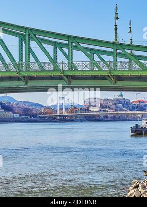 Die metallweiße Elisabeth-Brücke und die historische Buda-Burg auf dem Burgberg hinter den grünen Liberty Bridge-Bauten und der Donau, Budapes Stockfoto