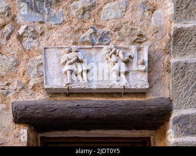 Eine geschnitzte Steintafel mit 5 Figuren ziert den Eingang zu einem Steinhaus im Dorf Villars sur Var in den Seealpen im Südosten Frankreichs Stockfoto