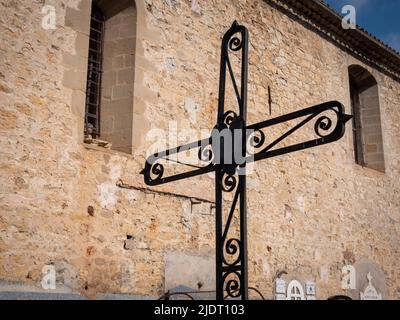 Ein schmiedeeisernes christliches Kreuz auf einem Friedhof neben der Hauptkirche im Dorf Villars-sur-Var in Provençal im Südosten Frankreichs Stockfoto