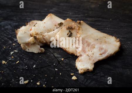 Appetitliche salo-Scheiben liegen auf einem dunklen Küchentisch Stockfoto