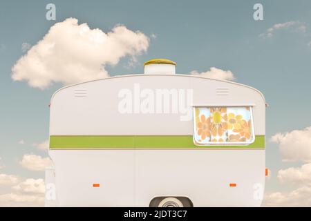 Vintage siebziger Jahre weißer Wohnwagen vor einem blauen Himmel mit Wolken Stockfoto