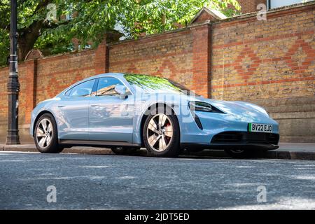 London - Mai 2022: Porsche Taycan 4S Elektroauto auf der hellen Londoner Straße geparkt Stockfoto