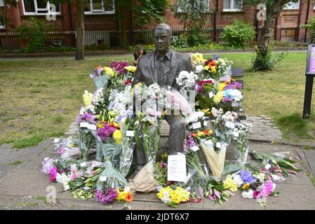 Manchester, Großbritannien. 23. Juni 2022. Blumensträuße, die am 23. Juni in Sackville Gardens im Zentrum von Manchester, Großbritannien, in der Alan Turing-Statue zum Geburtstag von Turing hinterlassen wurden. Turing gilt als der Vater der theoretischen Computerwissenschaft und künstlichen Intelligenz, spielte eine wichtige Rolle bei der Entwicklung von frühen Computern an der Universität Manchester und war ein berühmter Codebrecher aus dem Zweiten Weltkrieg. Die Wohltätigkeitsorganisation „Gleichstellungszeit“ übernimmt die Führung und hinterlässt Blumen an diesem Tag. Kredit: Terry Waller/Alamy Live News Stockfoto