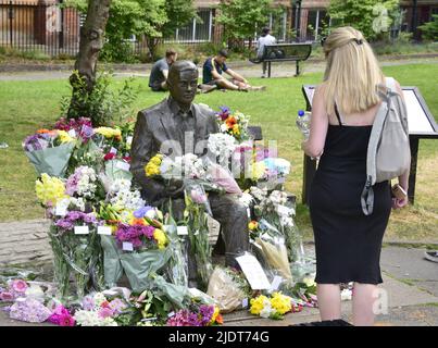 Manchester, Großbritannien. 23. Juni 2022. Blumensträuße, die am 23. Juni in Sackville Gardens, im Zentrum von Manchester, England, in der Alan Turing-Statue zum Geburtstag von Turing hinterlassen wurden. Turing gilt als der Vater der theoretischen Computerwissenschaft und künstlichen Intelligenz, spielte eine wichtige Rolle bei der Entwicklung von frühen Computern an der Universität Manchester und war ein berühmter Codebrecher aus dem Zweiten Weltkrieg. Die Wohltätigkeitsorganisation „Gleichstellungszeit“ übernimmt die Führung und hinterlässt Blumen an diesem Tag. Kredit: Terry Waller/Alamy Live News Stockfoto