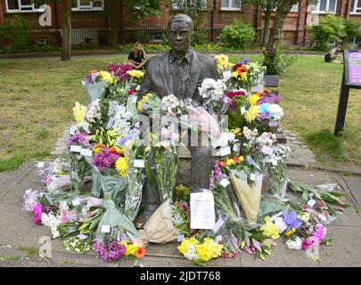 Manchester, Großbritannien. 23. Juni 2022. Blumensträuße, die am 23. Juni in Sackville Gardens im Zentrum von Manchester, Großbritannien, in der Alan Turing-Statue zum Geburtstag von Turing hinterlassen wurden. Turing gilt als der Vater der theoretischen Computerwissenschaft und künstlichen Intelligenz, spielte eine wichtige Rolle bei der Entwicklung von frühen Computern an der Universität Manchester und war ein berühmter Codebrecher aus dem Zweiten Weltkrieg. Die Wohltätigkeitsorganisation „Gleichstellungszeit“ übernimmt die Führung und hinterlässt Blumen an diesem Tag. Kredit: Terry Waller/Alamy Live News Stockfoto