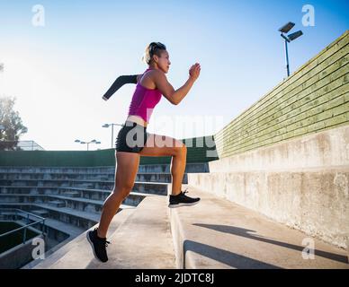 Sportlerin mit amputierter Hand, die Treppen hochläuft Stockfoto