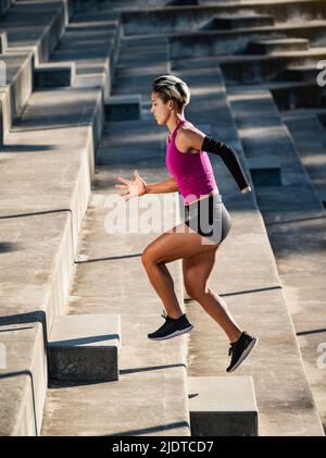 Sportlerin mit amputierter Hand, die Treppen hochläuft Stockfoto
