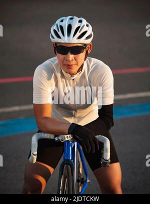 Porträt einer Sportlerin mit Armprothese auf dem Fahrrad Stockfoto
